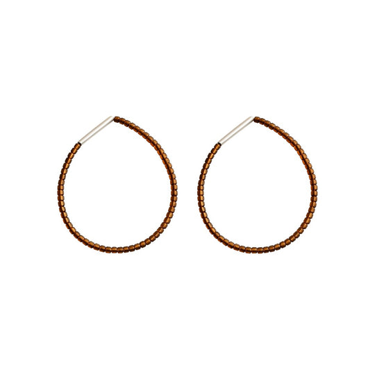 Pair of brown beaded sterling silver hoop earrings on a brown background
