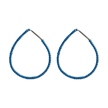 Pair of blue beaded hoop earrings on a white background