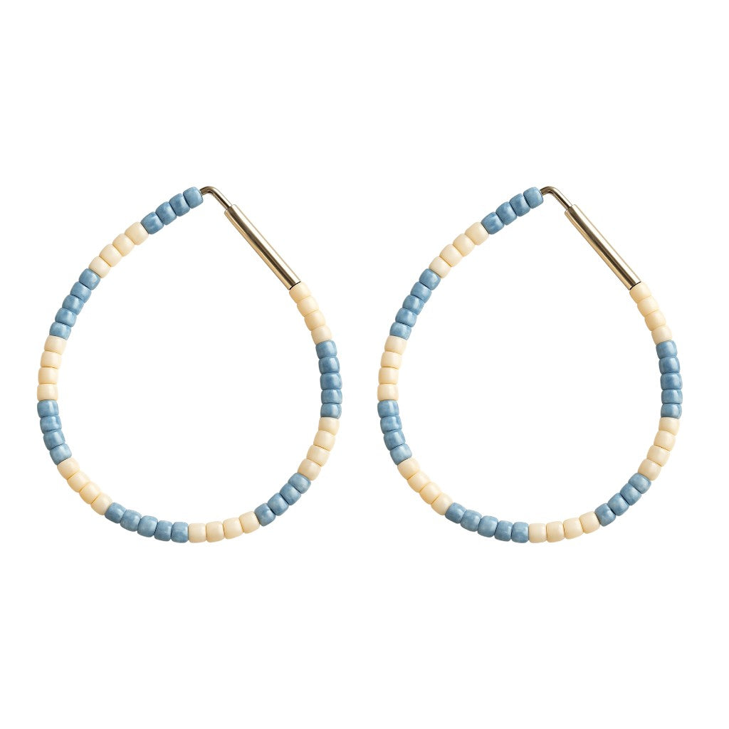 Pair of hoop earrings with blue and beige beads on a white background