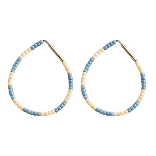 Pair of hoop earrings with blue and beige beads on a white background