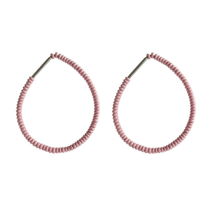 Pair of pink beaded hoop earrings on a white background