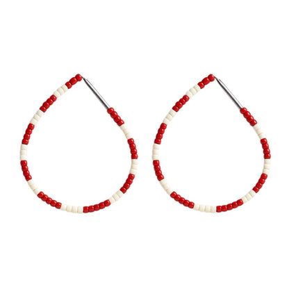 Pair of hoop earrings with red and white beads on a white background